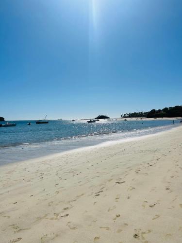 a beach with footprints in the sand and the water at A casa di Giorgia lodge Nosy be Andilana in Nosy Be