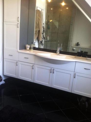 a bathroom with a sink and a large mirror at Beautiful townhouse with a garden in the best location in Copenhagen in Copenhagen