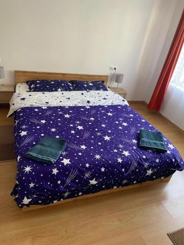 ein Bett mit einer lila Bettdecke mit Sternen darauf in der Unterkunft Casa Cătoiu in Sibiu