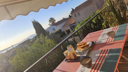 une table avec une assiette de nourriture sur un balcon dans l'établissement Parenthèse méditerranéenne - vue mer & terrasse, à La Ciotat