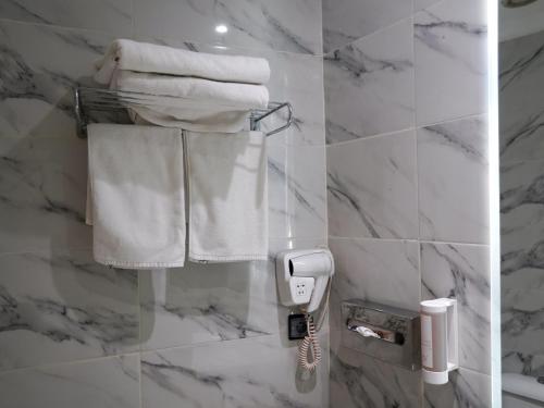 a hotel bathroom with white towels and a phone at Menzeh Zalagh 2Boutique Hôtel & Sky in Fès