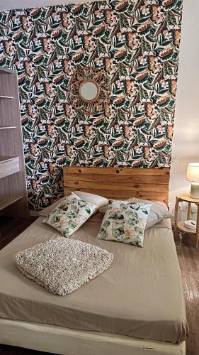 - un lit avec 2 oreillers et un mur avec dans l'établissement Grand T1 de 38 m2 au design épurée, à Marseille