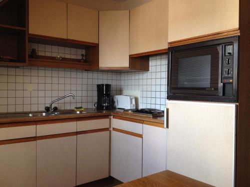 a kitchen with a microwave and a sink at Gîte Sonnenberg in Ammerschwihr