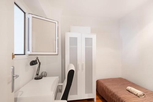 a room with a bed and a desk and a window at Cozy apartment centre Manresa in Manresa