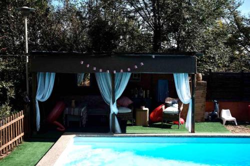- un auvent noir au-dessus d'une piscine dans une arrière-cour dans l'établissement Appartement dans maison individuelle, piscine, à La Tour-en-Jarez