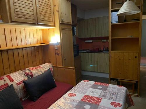 Cette petite chambre comprend un lit et une cuisine. dans l'établissement Plagne village 100% SKI aux pieds, à La Plagne Tarentaise