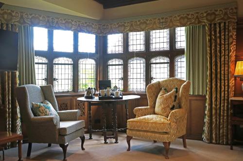 a room with two chairs and a table and windows at Hever Castle Luxury Bed and Breakfast in Edenbridge