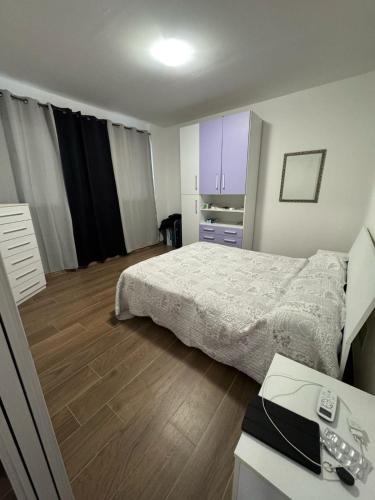 a bedroom with a bed and a desk with a phone at Appartamento Morelli Beach - Via Fratti in Follonica