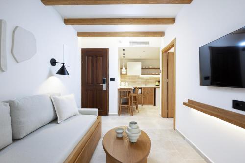 a living room with a white couch and a tv at Aegean Houses in Kos Town