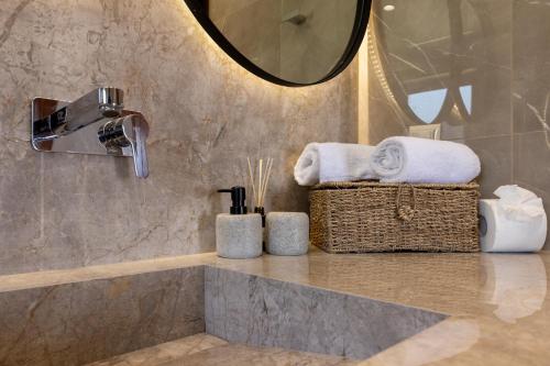 a bathroom with a counter with towels and a mirror at Villas Almyrida in Almyrida