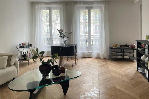 un salon avec une table en verre et un canapé dans l'établissement Spacious apartment with WiFi in the heart of Paris, à Paris