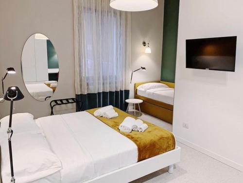 a hotel room with two beds and a mirror at Truly Verona in Verona