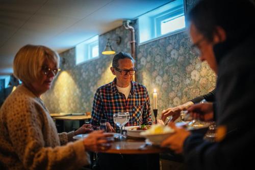 a group of people sitting at a table eating at Gårdshuset Vandrarhem in Undersåker