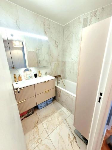 une salle de bain blanche avec un lavabo et une baignoire dans l'établissement Elegant appartement tout confort, à Saint-Germain-en-Laye