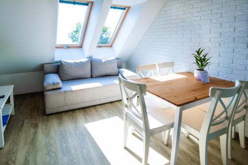 a living room with a table and a couch at Mazurskie Apartamenty "Jak Tu Miło!" in Węgorzewo