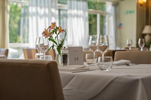 a table with wine glasses and a vase with flowers at The Clarendon Hotel in London