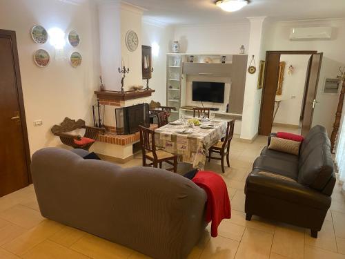 a living room with a couch and a table and chairs at Comfortable and spacious villa - Baia Domizia in Baia Domizia