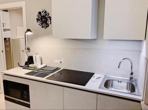a kitchen with white cabinets and a sink at Truly Verona in Verona