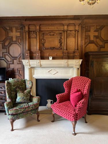 a living room with a chair and a fireplace at Hever Castle Luxury Bed and Breakfast in Edenbridge