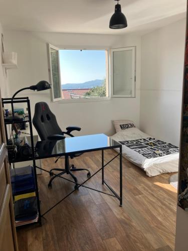 Cette chambre comprend un bureau, un lit et une fenêtre. dans l'établissement villa à bormes les mimosas, à Bormes-les-Mimosas