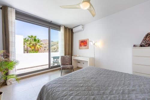 a bedroom with a bed and a large window at Casa Azahar playa Cabo De Gata 2 in Las Hortichuelas Bajas