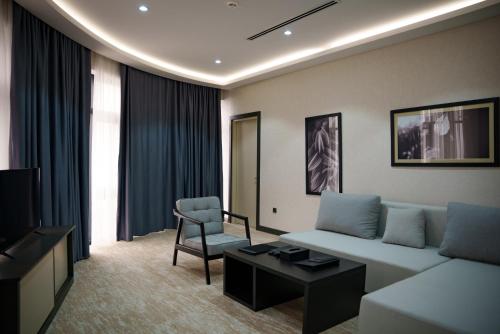 a living room with a couch and a chair at Green Village HOTEL & SPA in Sis