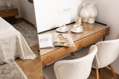 a table with two chairs and a table with a book at Apartments-Rooms Kocijancic in Bled
