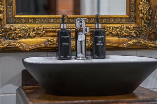 a sink with two bottles on it in front of a mirror at Ataraxia Place in Krugersdorp