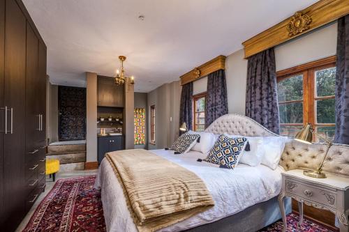 a bedroom with a large bed and a kitchen at Ataraxia Place in Krugersdorp