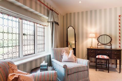 a living room with a chair and a mirror at Hever Castle Luxury Bed and Breakfast in Edenbridge