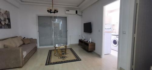 a living room with a couch and a table at ConfortTek apartment in Boumhel El Bassatine
