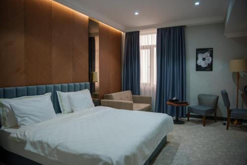 a hotel room with a bed and a chair at Green Village HOTEL & SPA in Sis