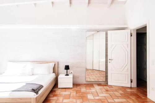a bedroom with a white bed and a white door at Mansarda Gentilino by Quokka 360 - Charming attic retreat in nature in Collina d'Oro