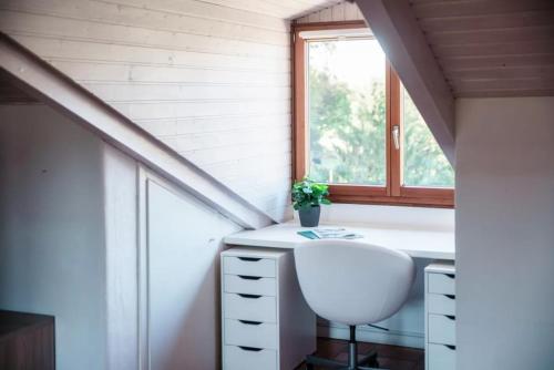 a white desk in a room with a window at Mansarda Gentilino by Quokka 360 - Charming attic retreat in nature in Collina d'Oro