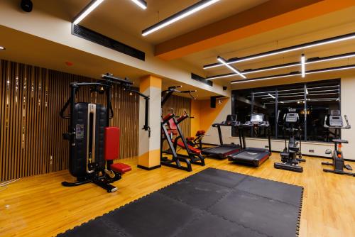 a gym with several treadmills and other equipment in a room at Green Village HOTEL & SPA in Sis
