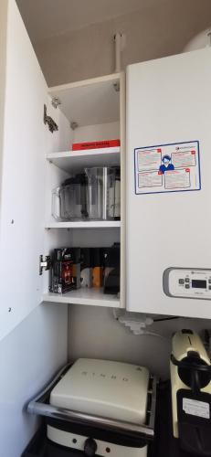 an open refrigerator drawer with a laptop in it at ConfortTek apartment in Boumhel El Bassatine