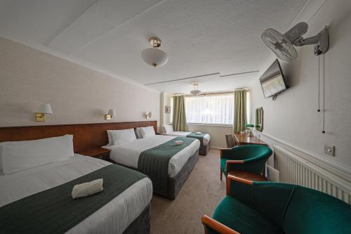 a hotel room with two beds and a couch at The Clarendon Hotel in London