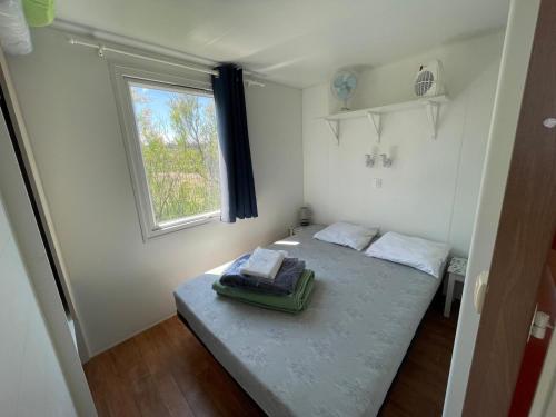 une petite pièce avec un lit et une fenêtre dans l'établissement Camping Seasonova Ensoya, à Sigean