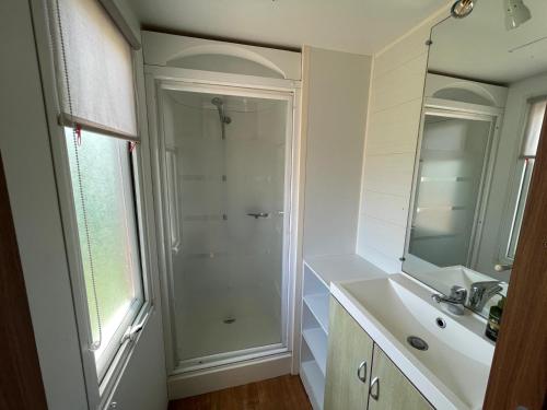 une salle de bain blanche avec une douche et un lavabo dans l'établissement Camping Seasonova Ensoya, à Sigean