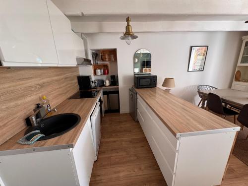 une cuisine avec un évier et un plan de travail dans l'établissement Maison au coeur du port de Sauzon, à Sauzon