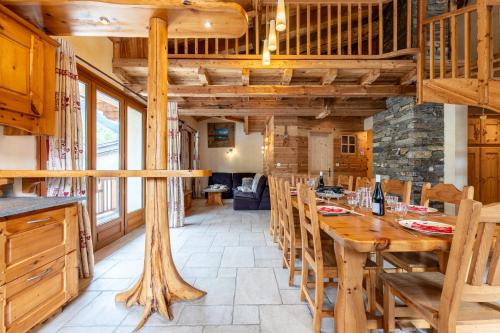 une salle à manger avec une table et des chaises en bois dans l'établissement Savine 10- 11 personnes, à Val Cenis