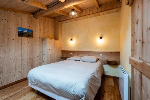 a bedroom with a bed in a wooden room at Savine 10- 11 personnes in Val Cenis