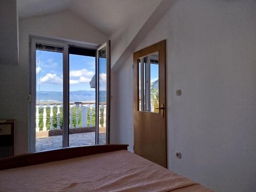 a bedroom with a bed and a large window at Hilltop Villa Risika in Risika
