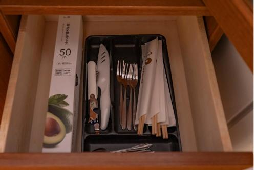a drawer filled with utensils in a cabinet at Le Nessa Jyogasaki in Ito