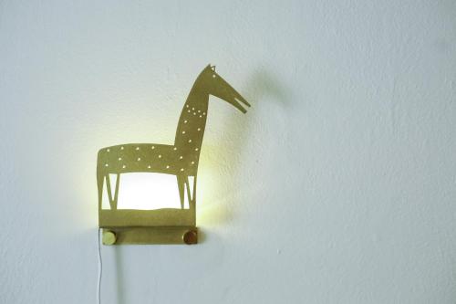 a wooden toy giraffe hanging on a wall at Neot Semadar Eco Lodge in Naẖal Ya‘alon