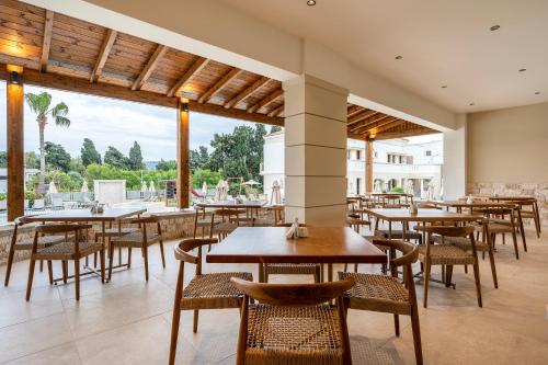 a restaurant with tables and chairs and a large window at Aegean Houses in Kos Town