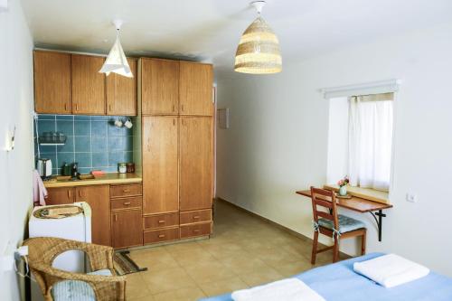 a kitchen with wooden cabinets and a table and a desk at Neot Semadar Eco Lodge in Naẖal Ya‘alon