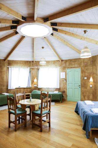 a room with a table and chairs and a ceiling at Neot Semadar Eco Lodge in Naẖal Ya‘alon