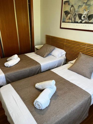 three beds in a hotel room with towels on them at Ocean View Apartment in Alicante