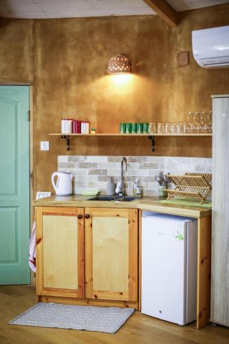 a kitchen with a sink and a white refrigerator at Neot Semadar Eco Lodge in Naẖal Ya‘alon